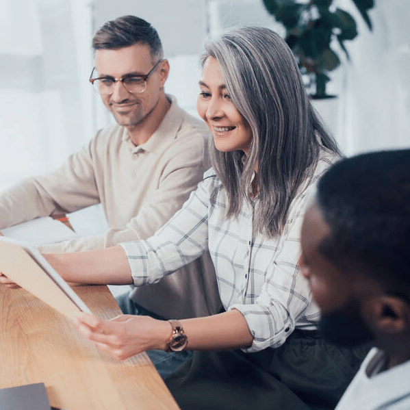 stock-photo-smiling-multicultural-colleagues-looking-folder-meeting-creative-agency
